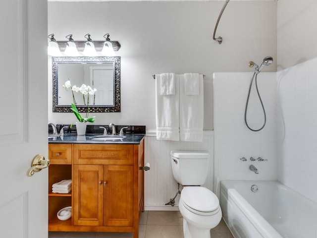 full bath featuring toilet, tile patterned flooring, washtub / shower combination, wainscoting, and vanity