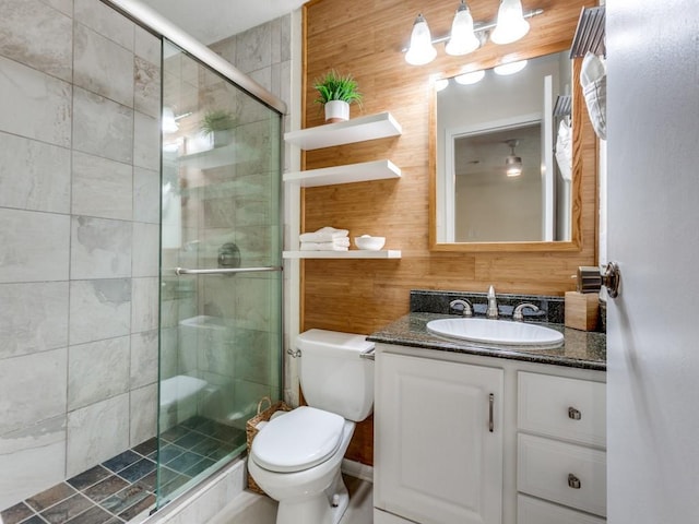 bathroom with vanity, a shower stall, and toilet