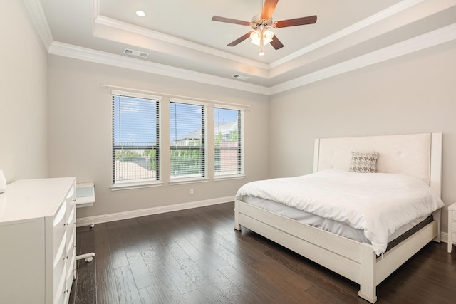 bedroom with visible vents, crown molding, baseboards, dark wood-type flooring, and a tray ceiling