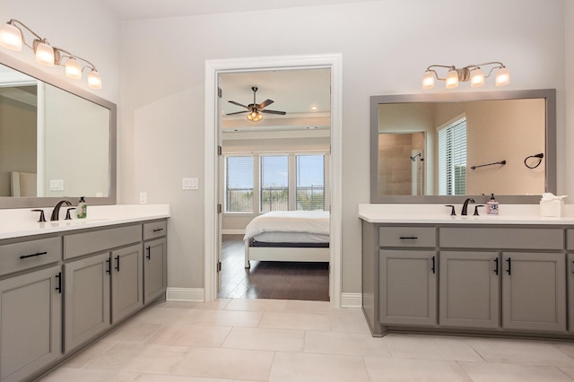 ensuite bathroom with a tile shower, connected bathroom, a ceiling fan, and a sink