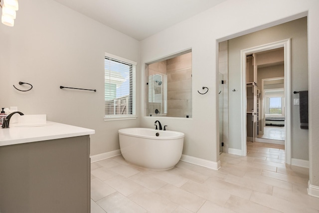 full bath with vanity, baseboards, a stall shower, and a freestanding bath