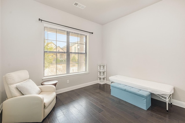 sitting room featuring visible vents, baseboards, and dark wood finished floors