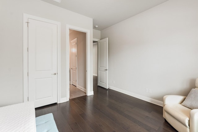 unfurnished room with baseboards and dark wood-type flooring