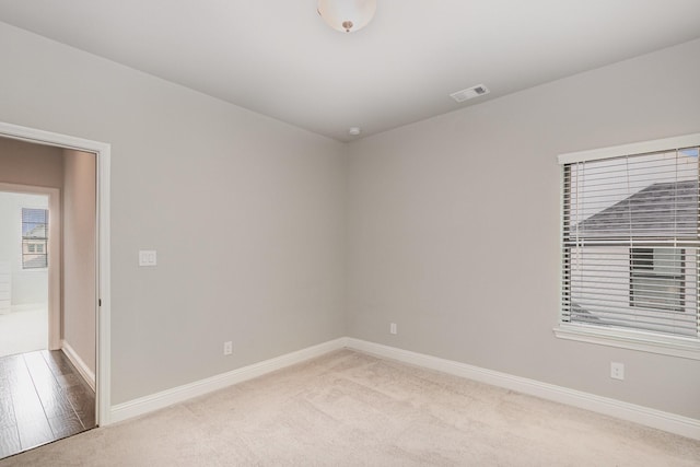 unfurnished room with carpet, baseboards, and visible vents