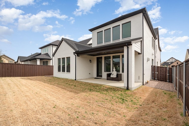 back of house with a patio, a yard, a fenced backyard, and brick siding