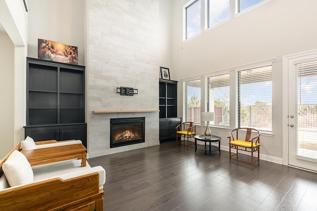 sitting room featuring wood finished floors, a wealth of natural light, and a tile fireplace