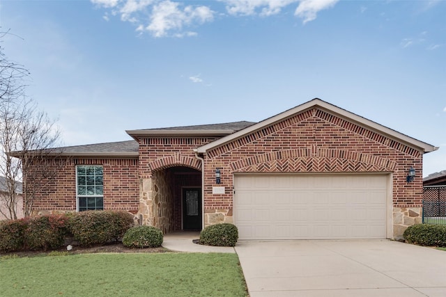 view of front of property with driveway, stone siding, an attached garage, a shingled roof, and brick siding