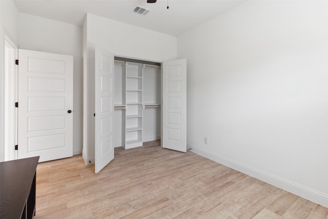 unfurnished bedroom with a closet, visible vents, baseboards, and light wood-style floors