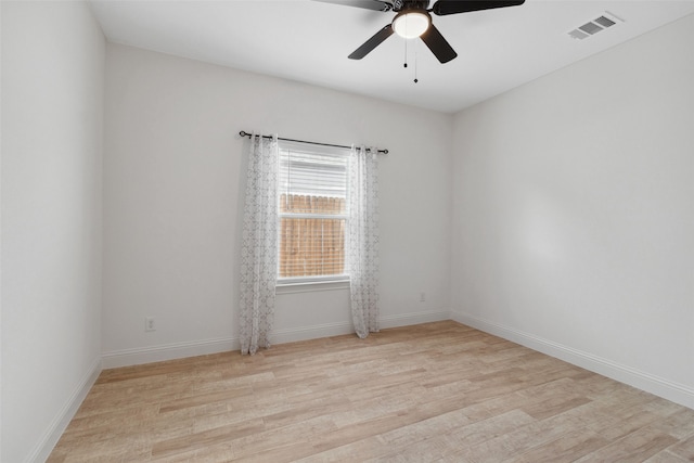 spare room with visible vents, baseboards, ceiling fan, and wood finished floors