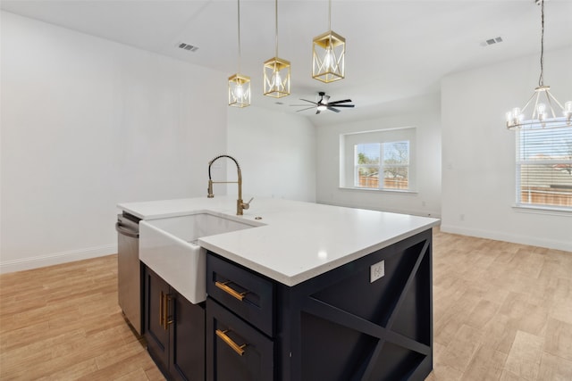 kitchen featuring light wood finished floors, visible vents, light countertops, and a sink