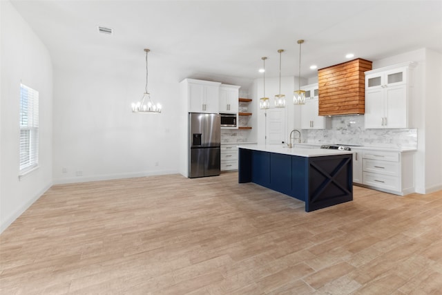 kitchen with an inviting chandelier, open shelves, stainless steel appliances, decorative backsplash, and light countertops