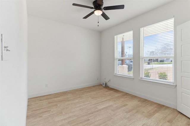 unfurnished room featuring light wood-style flooring, a healthy amount of sunlight, and baseboards