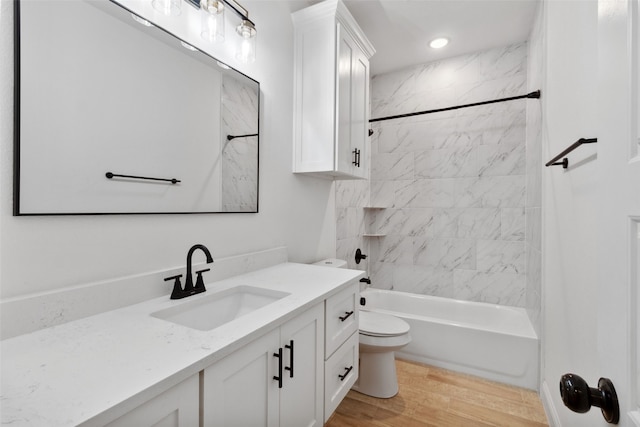 full bath featuring toilet, wood finished floors, recessed lighting, vanity, and shower / bathtub combination