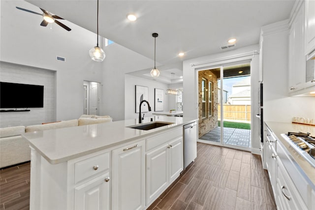 kitchen with wood finish floors, open floor plan, visible vents, and a sink