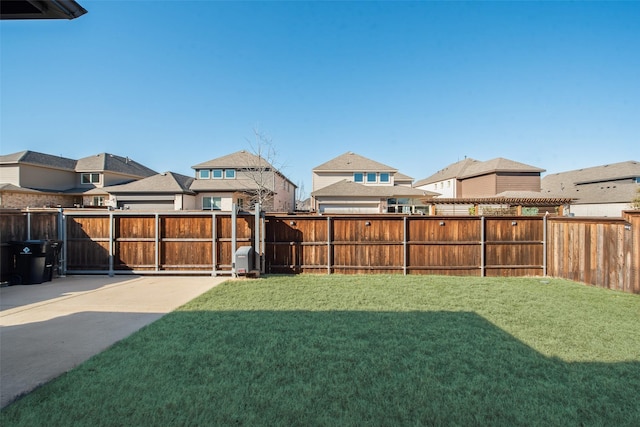 view of yard featuring a residential view, a patio, and a fenced backyard