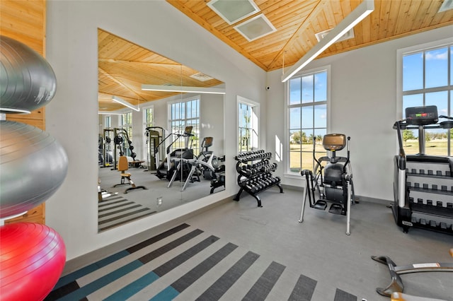 workout area with a healthy amount of sunlight, wooden ceiling, and lofted ceiling