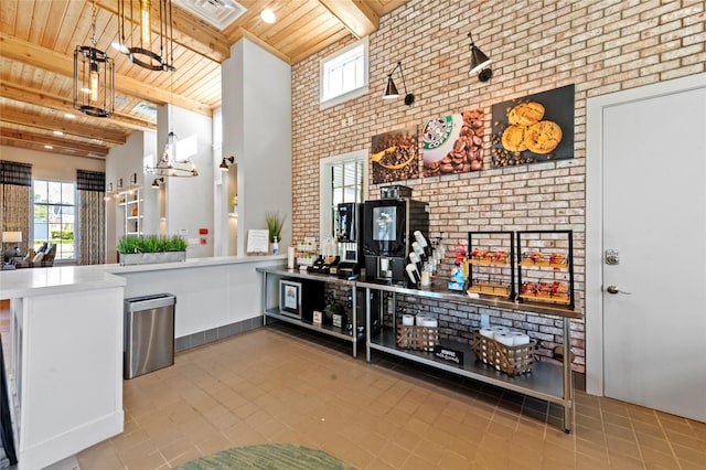 kitchen with wooden ceiling, tile patterned floors, brick wall, and beam ceiling