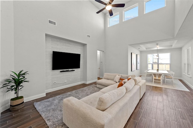 living room with visible vents, plenty of natural light, a ceiling fan, and wood finish floors