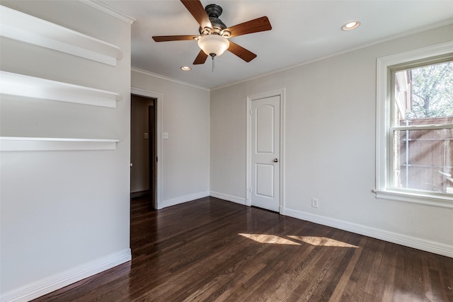 empty room featuring a ceiling fan, baseboards, dark wood finished floors, recessed lighting, and ornamental molding