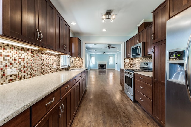 kitchen with dark wood-style floors, a sink, stainless steel appliances, dark brown cabinetry, and crown molding