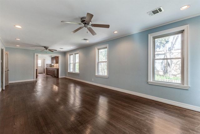 unfurnished living room featuring visible vents, ornamental molding, baseboards, ceiling fan, and dark wood-style flooring