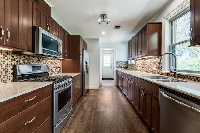 kitchen with visible vents, a sink, dark brown cabinetry, dark wood-type flooring, and appliances with stainless steel finishes