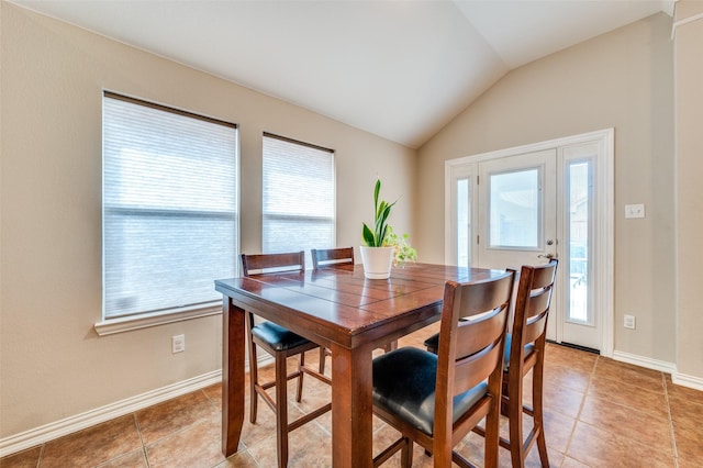 dining area with light tile patterned flooring, baseboards, and lofted ceiling