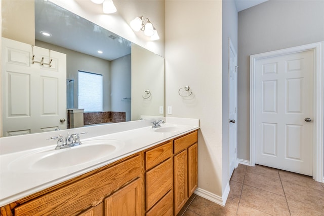 full bath featuring tile patterned flooring, double vanity, baseboards, and a sink