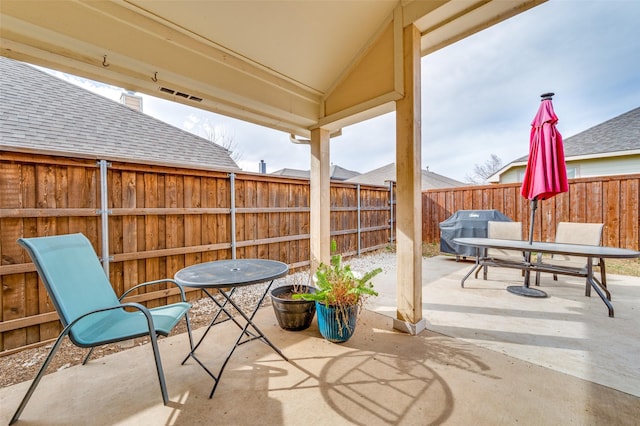 view of patio with a grill, outdoor dining area, and fence