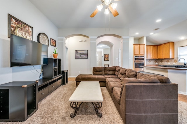 living room with ceiling fan, vaulted ceiling, recessed lighting, arched walkways, and ornate columns