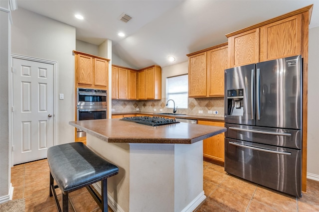 kitchen with a sink, stainless steel appliances, backsplash, and visible vents