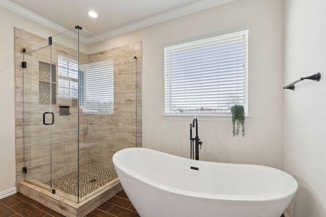 full bathroom featuring a freestanding tub, a stall shower, wood tiled floor, and ornamental molding