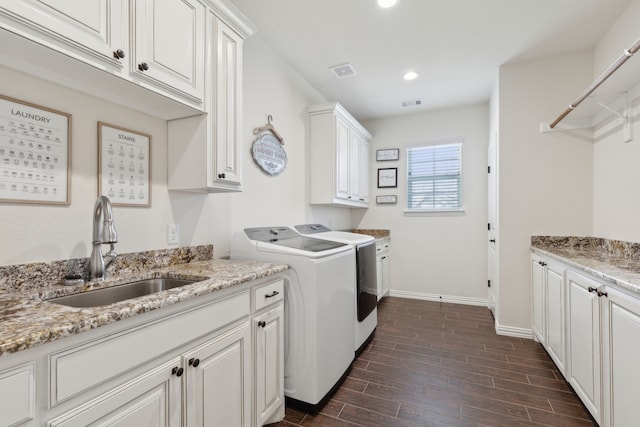 laundry room with visible vents, wood finish floors, washer and clothes dryer, cabinet space, and a sink