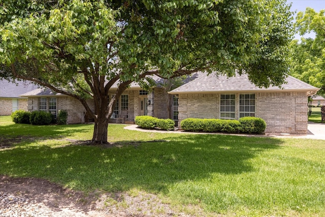 5710 Nutcracker Dr, Granbury, TX 76049 - view of front of house with a front lawn, brick siding, and roof with shingles