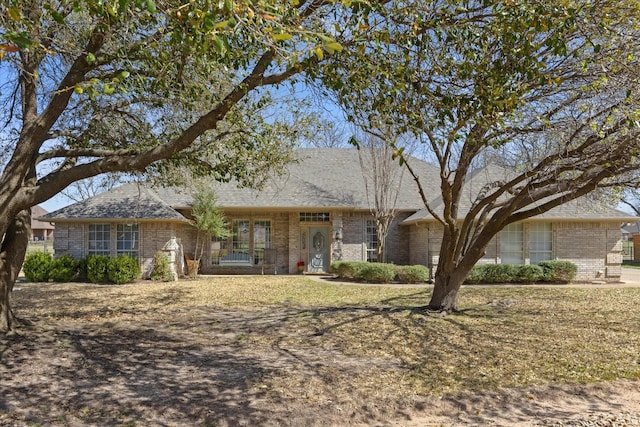 single story home featuring brick siding and a shingled roof
