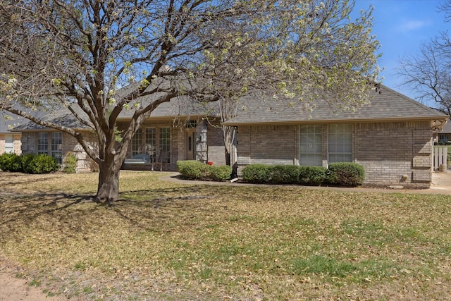 view of front facade with a front lawn and brick siding