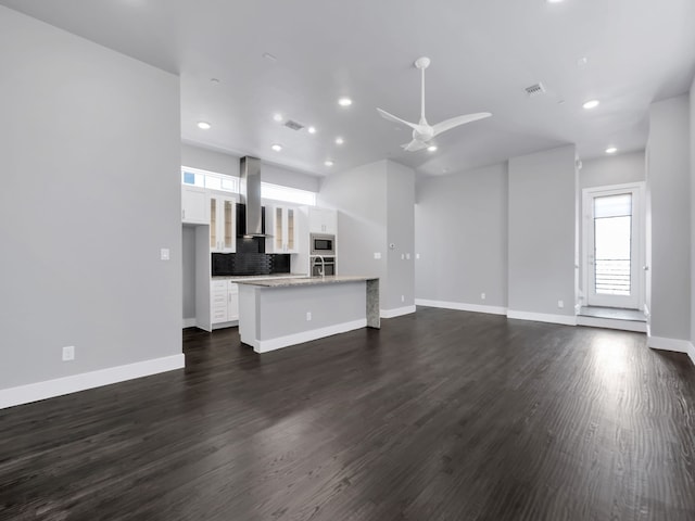 unfurnished living room with visible vents, dark wood-type flooring, baseboards, recessed lighting, and a ceiling fan