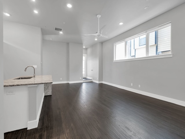 unfurnished living room featuring a sink, baseboards, dark wood-style floors, and recessed lighting