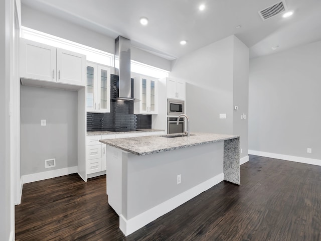 kitchen with visible vents, an island with sink, appliances with stainless steel finishes, island range hood, and white cabinets