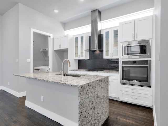 kitchen featuring dark wood-style floors, washer / dryer, a sink, stainless steel appliances, and island range hood