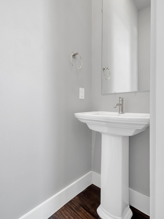 bathroom featuring a sink, baseboards, and wood finished floors