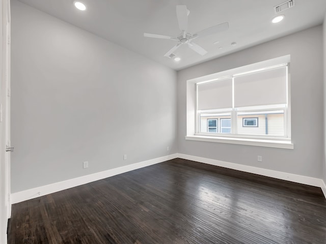 empty room with visible vents, baseboards, and dark wood-style floors