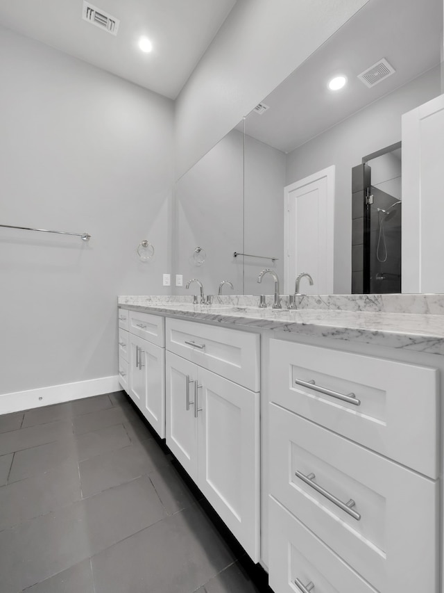 full bathroom with baseboards, visible vents, vanity, and walk in shower