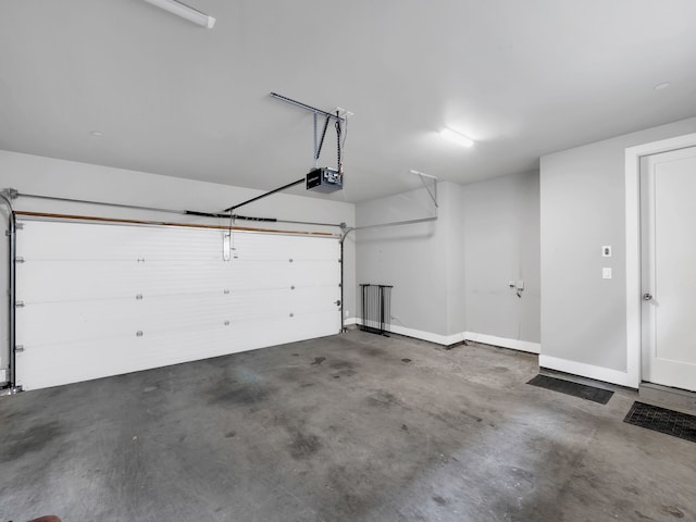 garage featuring a garage door opener and baseboards