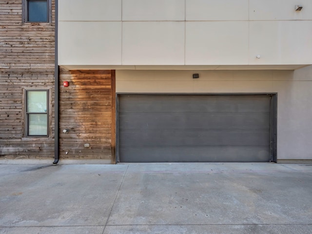 garage with a carport and concrete driveway