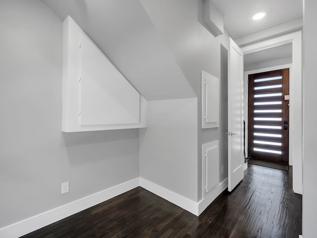 bonus room featuring dark wood-type flooring and baseboards