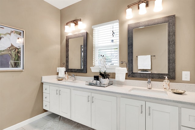 full bathroom with tile patterned floors, double vanity, baseboards, and a sink