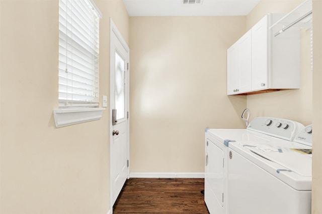 washroom with visible vents, dark wood-type flooring, cabinet space, baseboards, and washing machine and clothes dryer