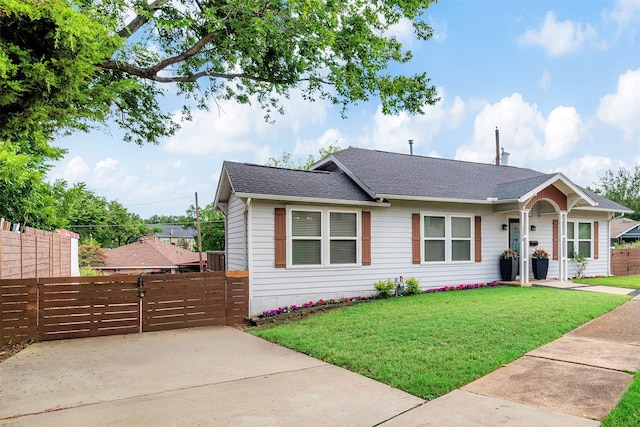 single story home featuring roof with shingles, a front lawn, and fence