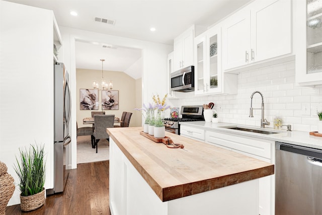 kitchen with visible vents, wooden counters, stainless steel appliances, and a sink